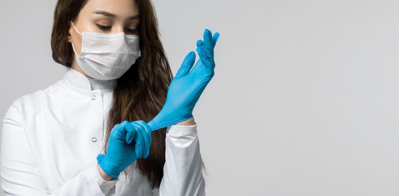 mujer morena se pone guantes azules para evitar la contaminación. ella está usando rimel