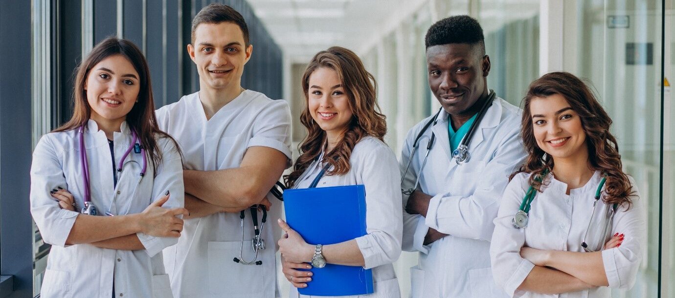 Young doctors together in a hospital corridor with their artboards and medical utensils