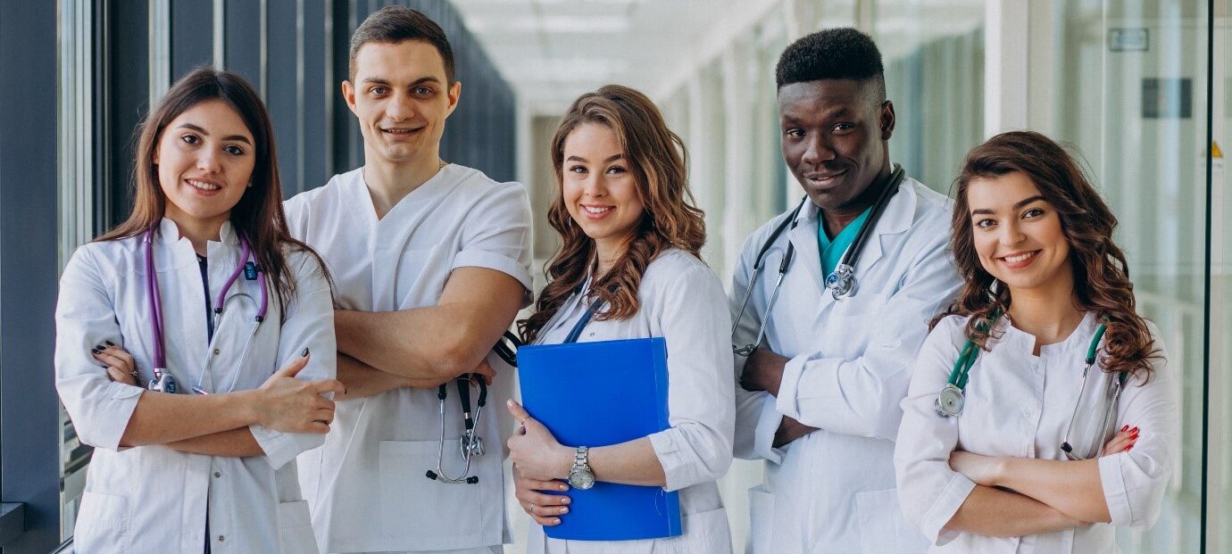 jóvenes doctores juntos en el pasillo de un hospital con sus portapapeles y herramientas médicas